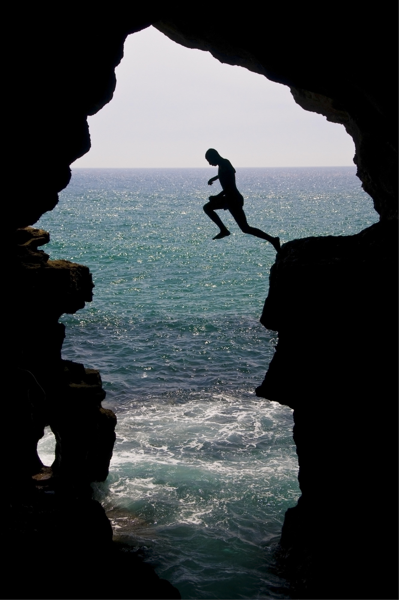 Moroccan man jumps into the ocean in the Hercules Cave near Tangier, Morocco.