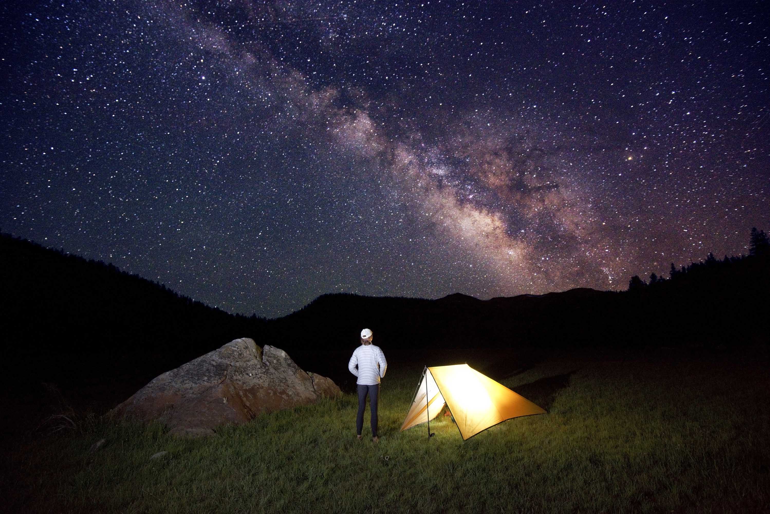 Fastpacker Meghan Hicks looks up at the Milky Way while camping in Big Meadow on the Tahoe Rim Trail, CA. 