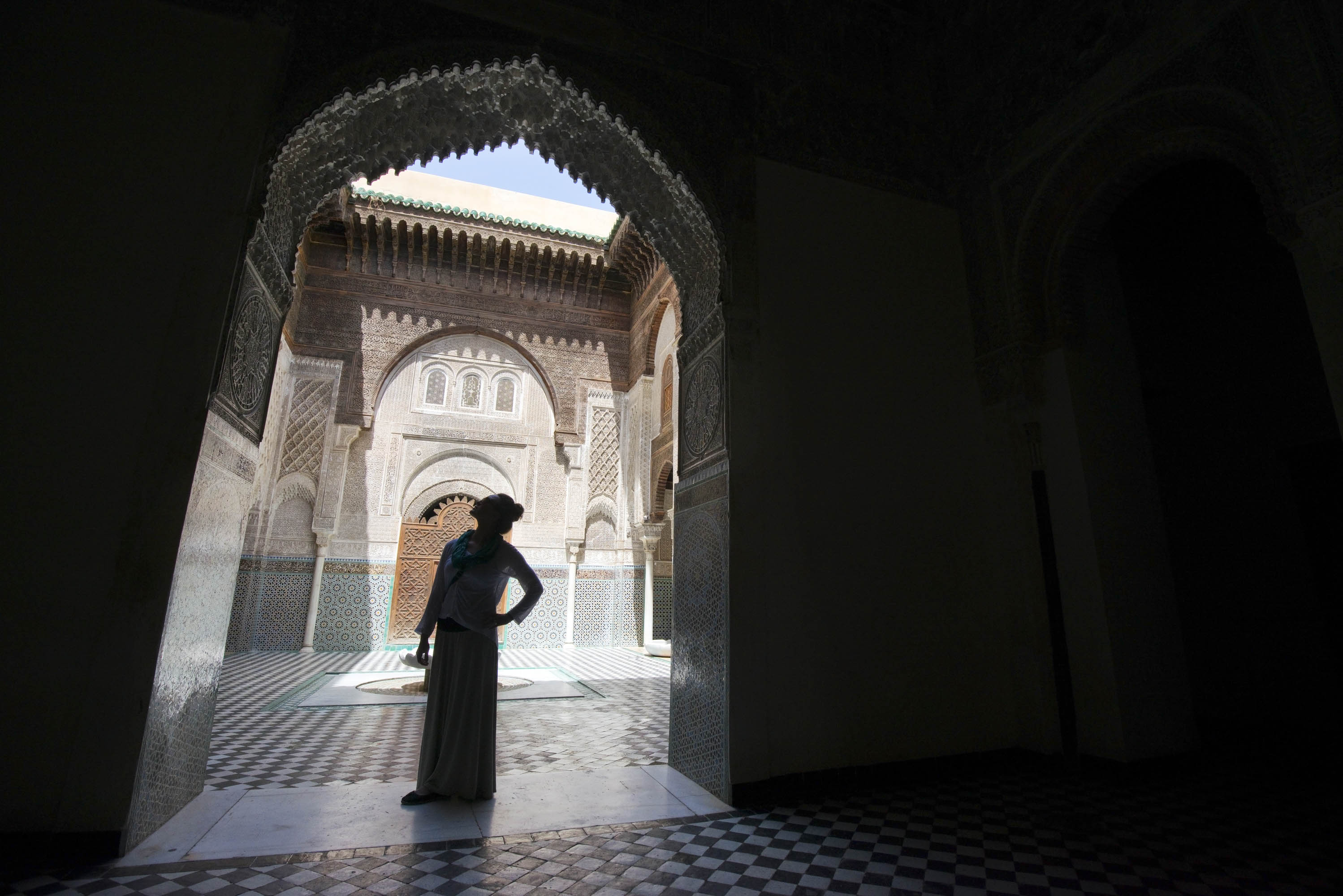 Woman stands silhouetted in Madrasa Bou Inania in Fes el-Bali, Fes, Morocco.